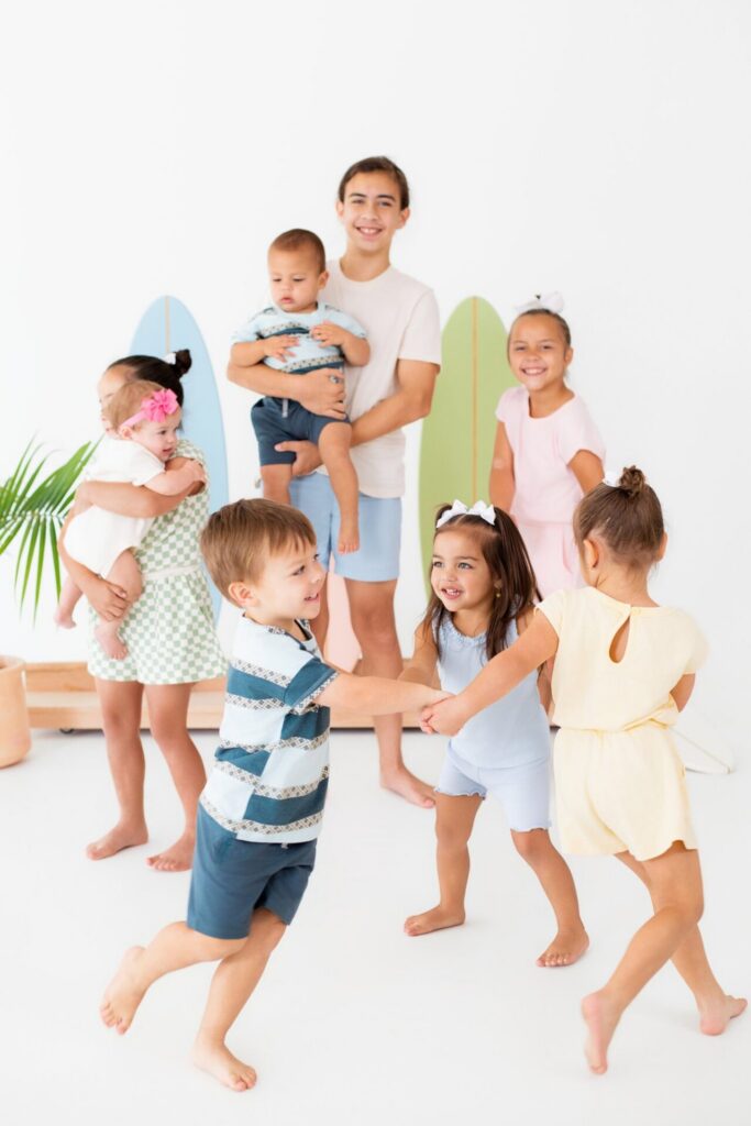 Cousins and kids playing together on beach-inspired summer photo studio set at Jacksonville natural light studio.