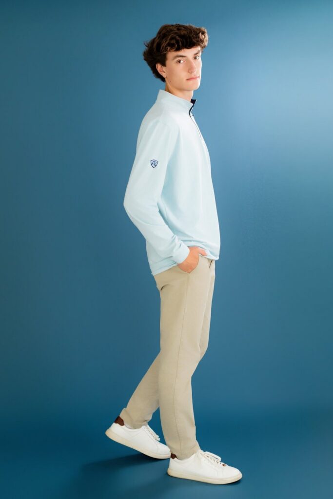 Simple clean high school graduate portrait with blue backdrop during studio graduation session in Jacksonville, FL.
