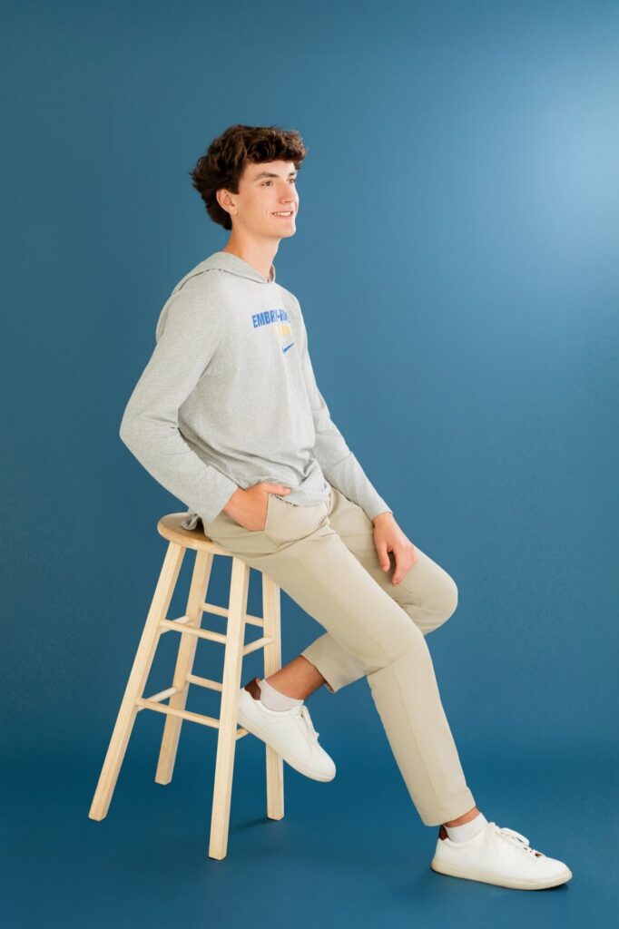 Simple clean high school graduate portrait of senior sitting in studio during graduation photo session in Jacksonville, FL.