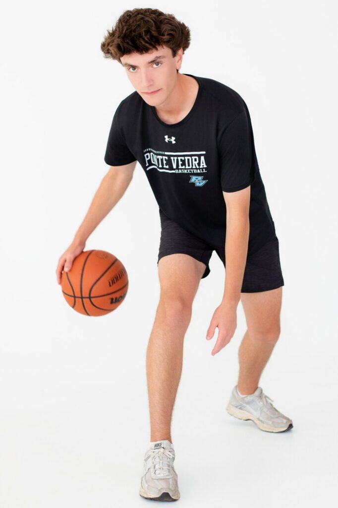 Ponte Vedra, FL basketball student athlete dribbling basketball during high school senior portrait session in studio.