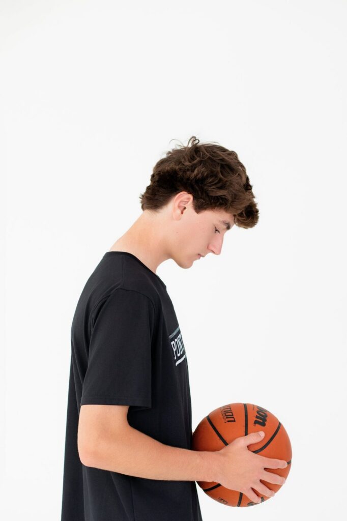 Ponte Vedra, FL high school senior portrait of basketball student athlete holding basketball during graduation studio session.