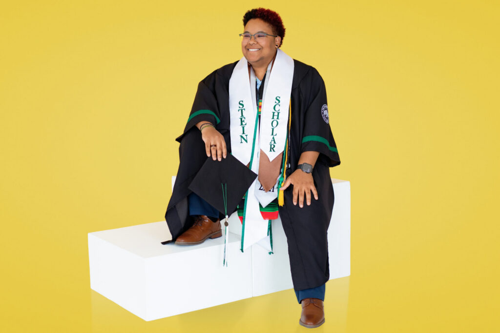 Jacksonville university senior class of 2026 graduation portrait featuring graduates cap, gown and honor cords during colorful studio session in Florida school colors.