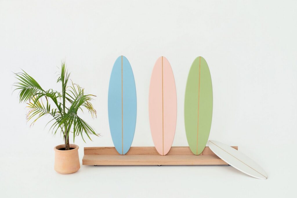 Summer photo studio installation at Jacksonville natural light studio featuring multicolored surfboards and real palm tree for coastal-inspired portraits.