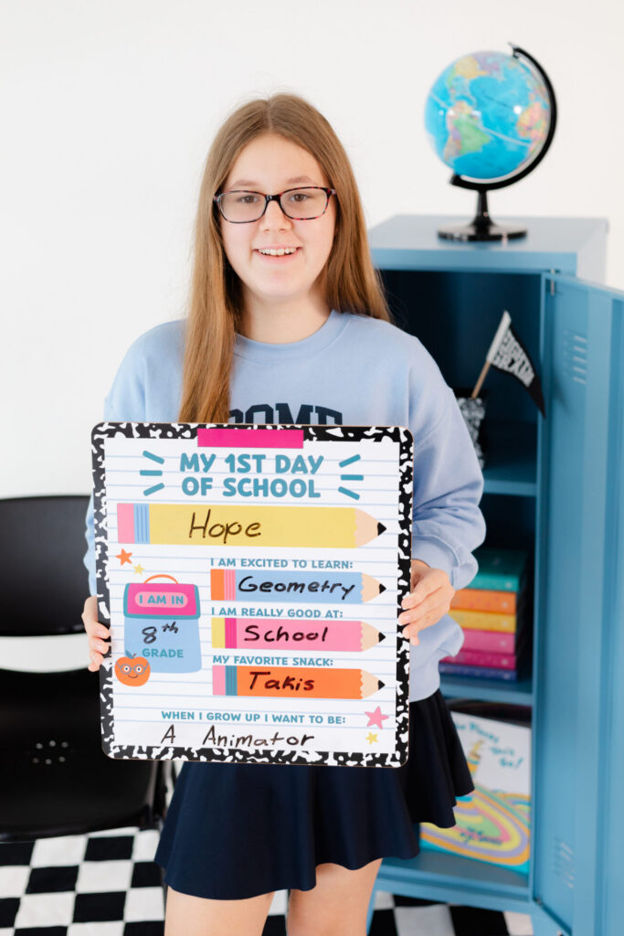 An 8th grade girl holding a first day of school sign for her back to school portraits at Jax Mini Sessions Studio