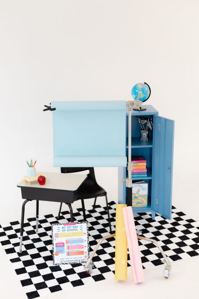 back to school themed photo studio set with a checkerboard rug, desk, and blue locker