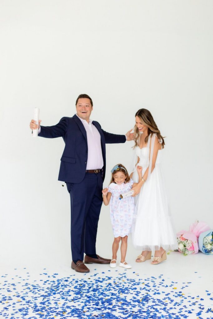 Family celebrates when they find out they are having a baby boy after confetti and flower bouquet gender reveal in Jacksonville, FL photo studio.