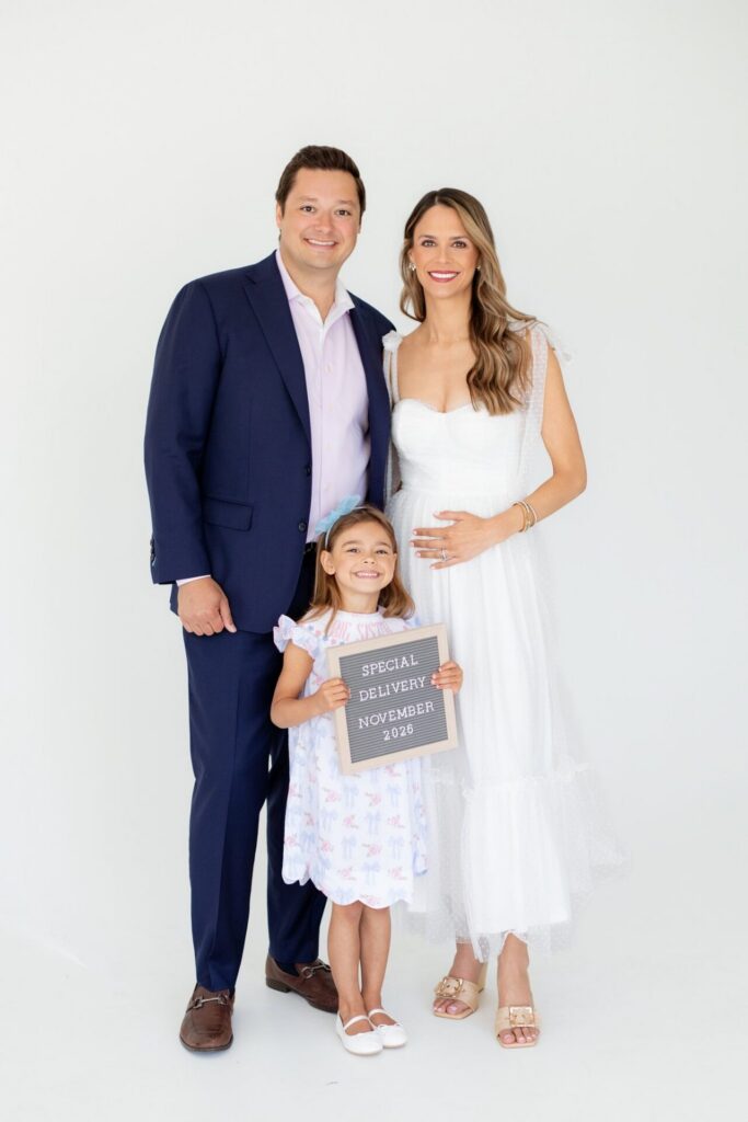 Family portrait of a pregnancy announcement with daughter holding a sign that says "Special Delivery" at a Jacksonville photo studio.