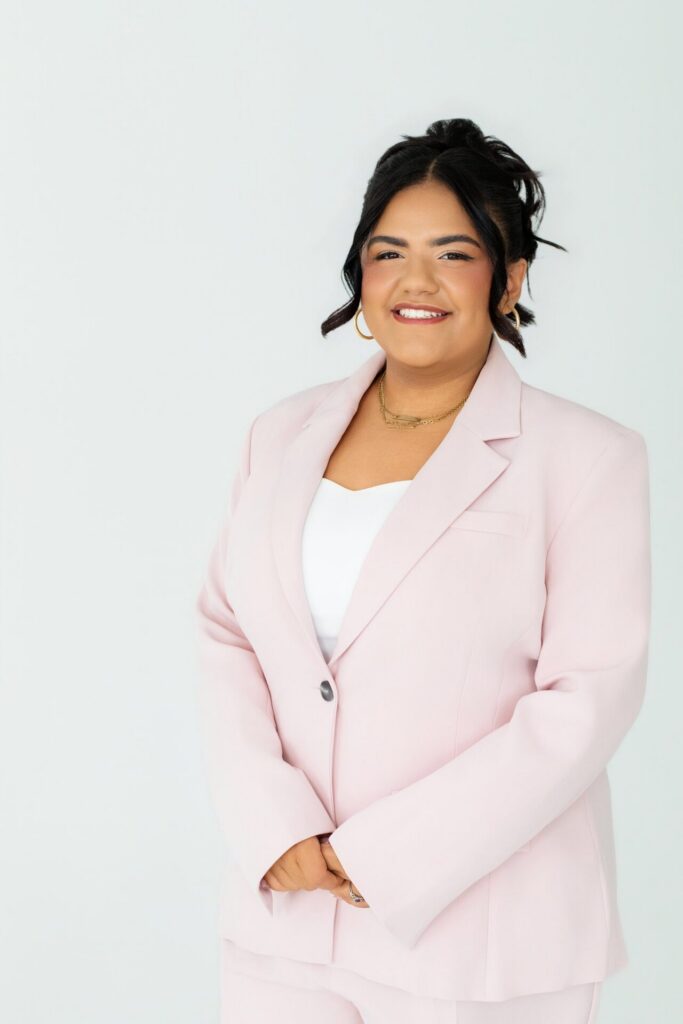 Deni of Deni Stylez Hair in Jacksonville, Florida posing in a pink blazer for a headshot during a branding session at indoor photo studio Jax Mini Sessions Studio